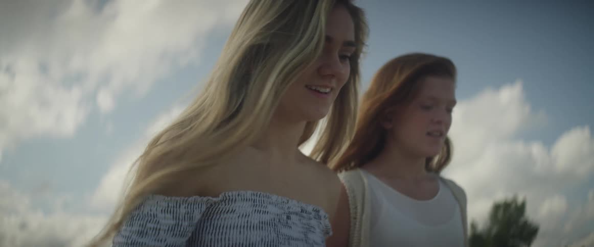 Two young girls walk on the beach