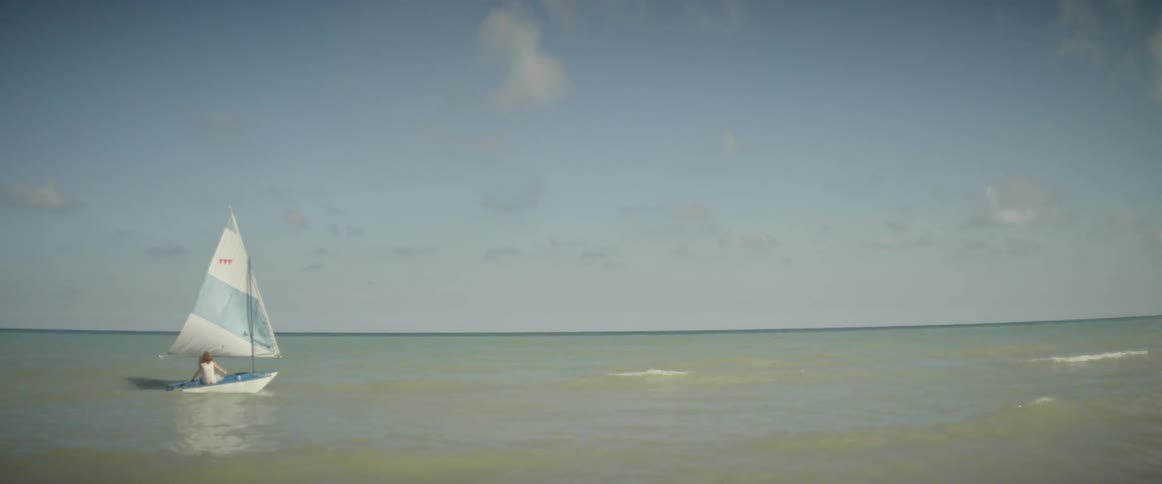 A person is riding in the small sailboat
