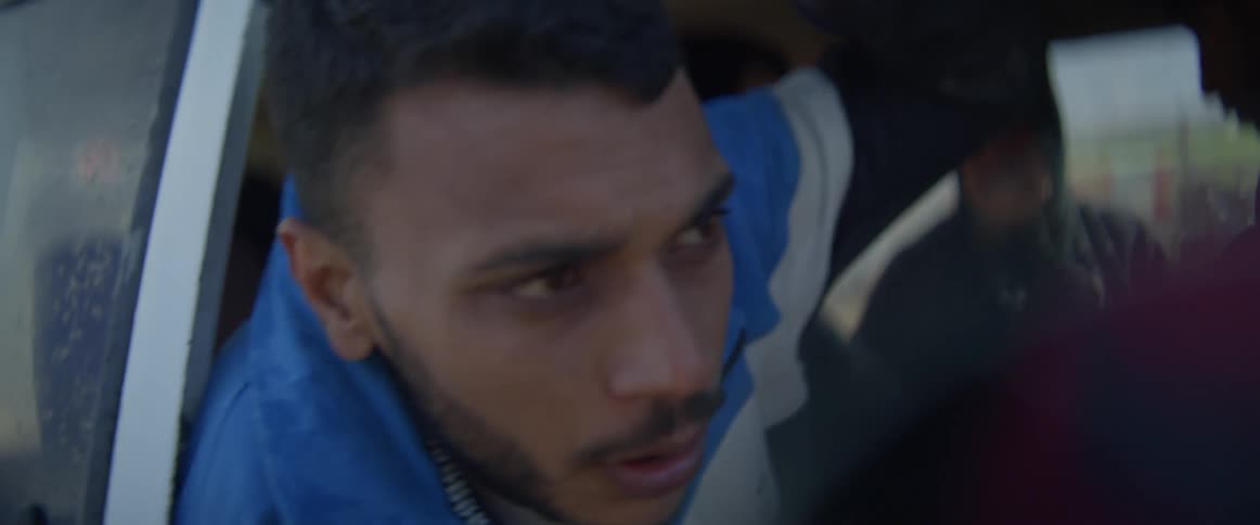 A man is getting into a van full of people after looking around