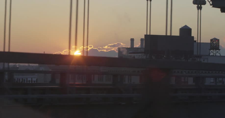 Driving across a suspension bridge at sunset