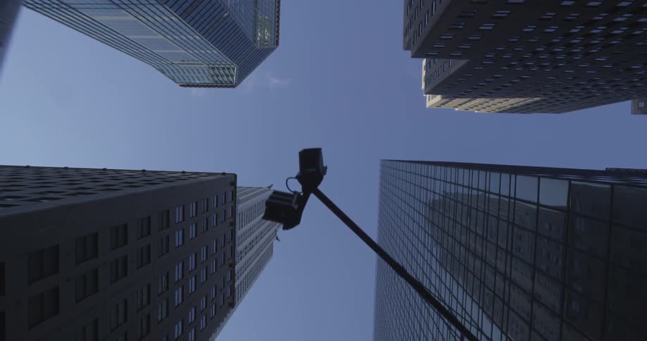 Skyscrapers and a traffic light towering overhead