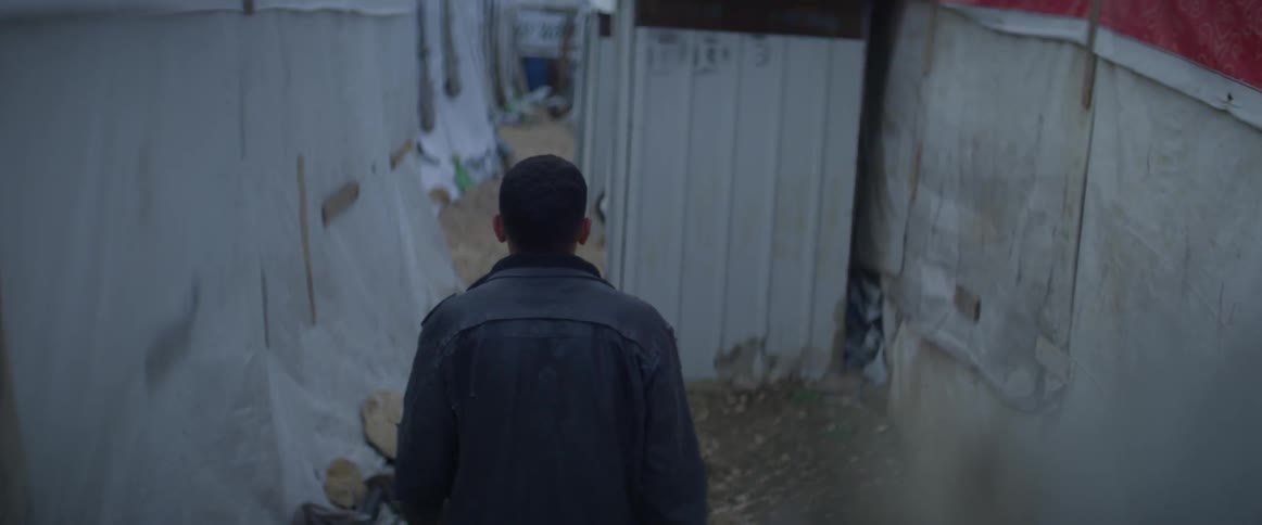 A man walks in between makeshift refugee structures