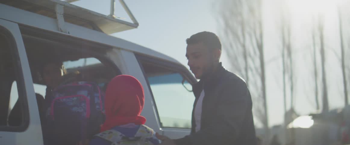Man directs children into a white van
