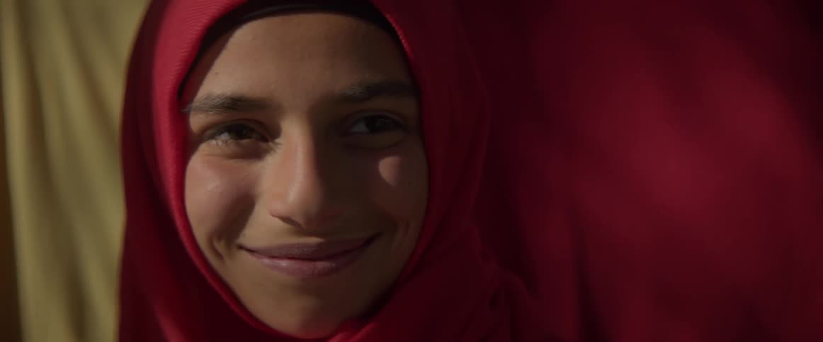 Smiling child stands outside