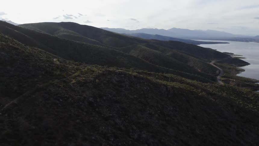 Clouds over rocky grassy mountains