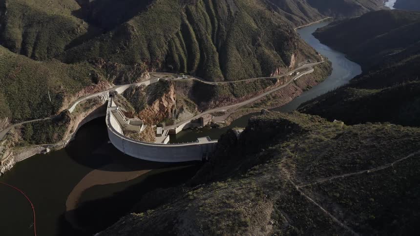 Dam blocks a small river in between mountains