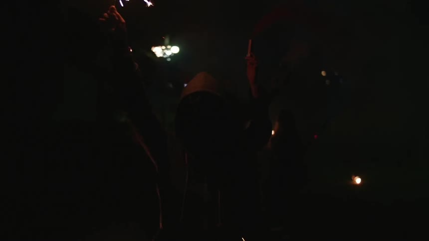 A group of people holding burning sparklers