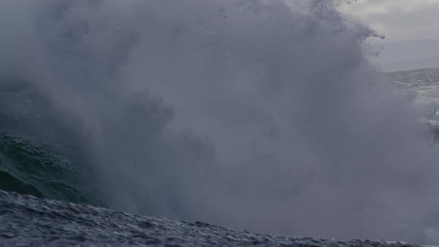 A close up of an ocean wave as a crests and then crashes down