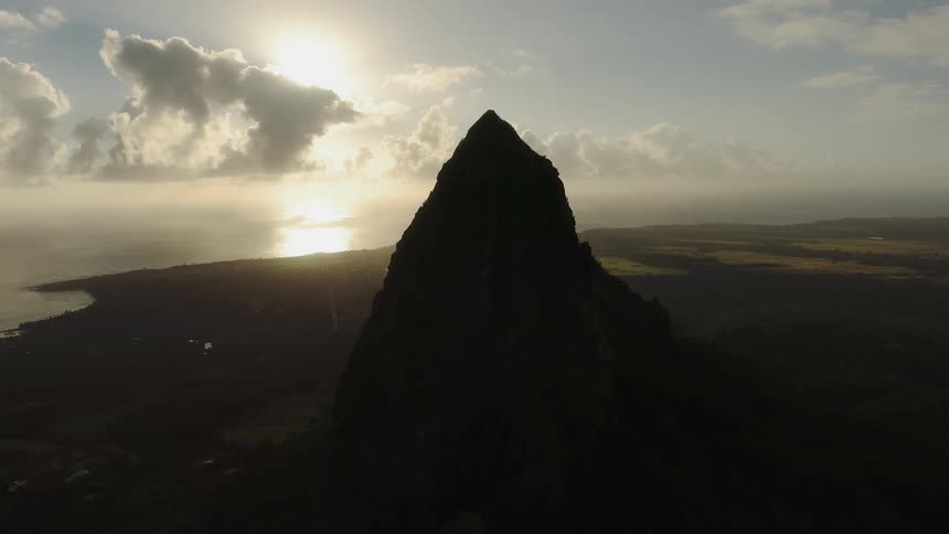A rocky peak overlooking the ocean on a sunny day