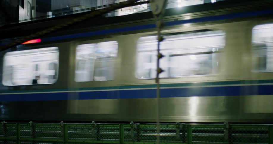 An elevated train travels through the city at night