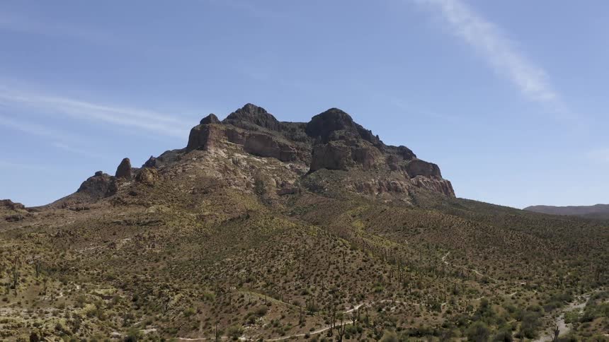 Large rocks sit on a hill under a blue sky