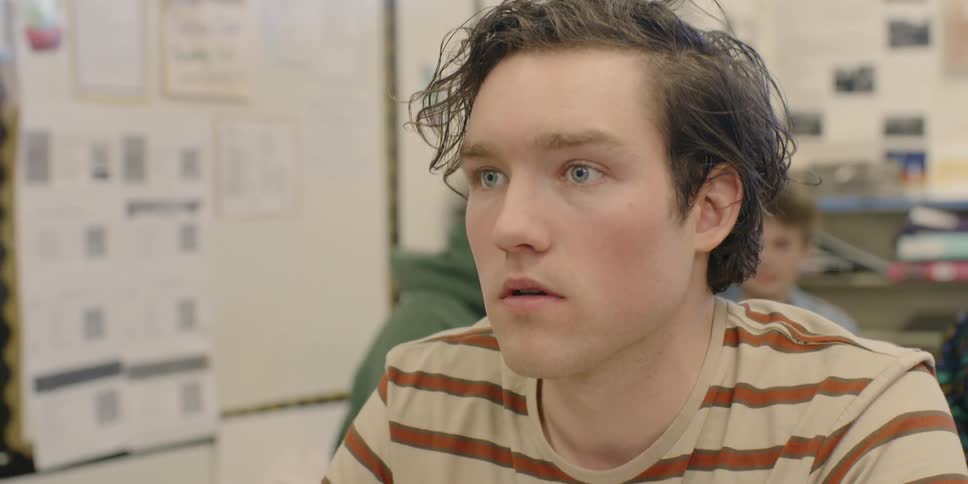 A teenager looks up sitting in the classroom