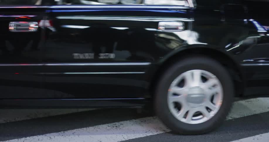 Two cars drive on a city street