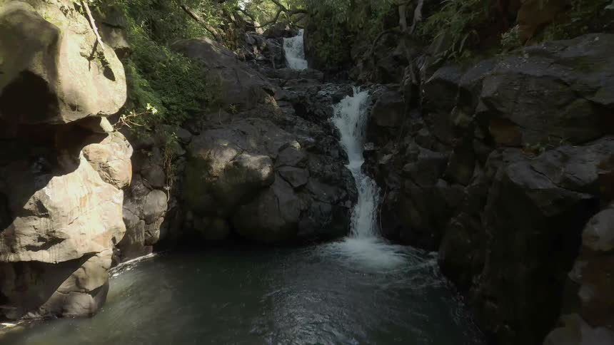 Water flows down over the rocks under a sunny sky