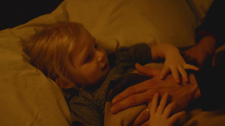 A young child is put to bed