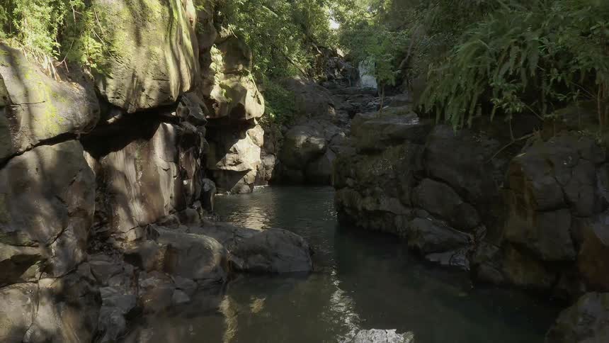 The stream is calm near the rocks