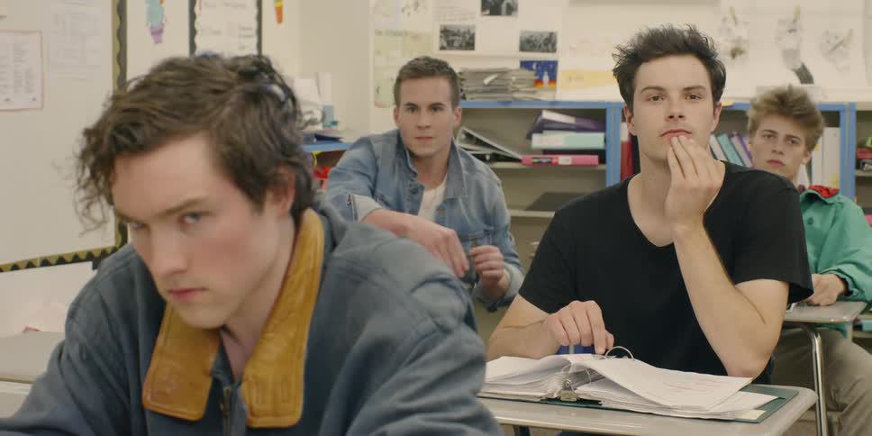 A boy throws balled up paper at another student in a classroom