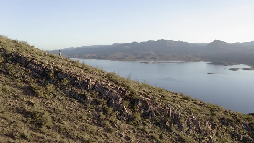 A rocky slope overlooking a lake on a sunny day