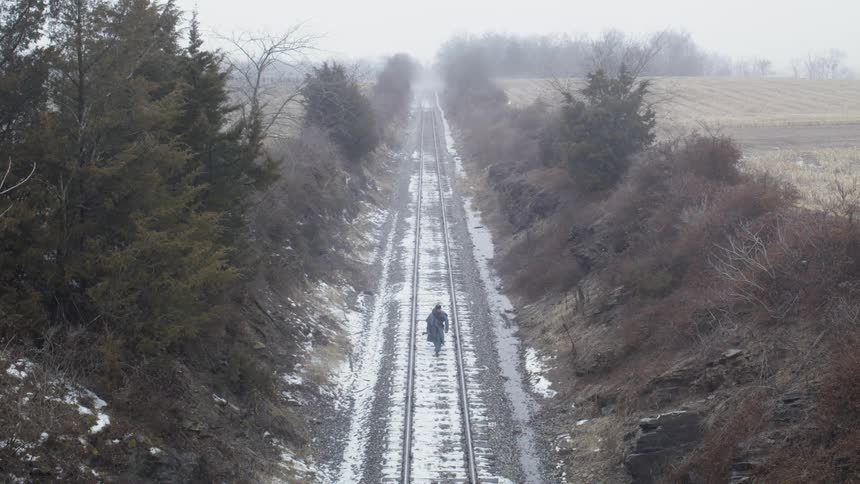 A man walks on railroad tracks