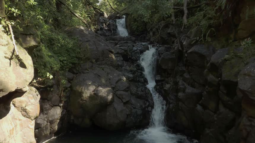 Small stream splashes down rocks into a pool below