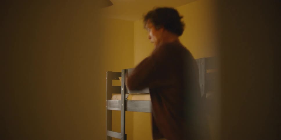 Man dances and waves his arms in a bedroom