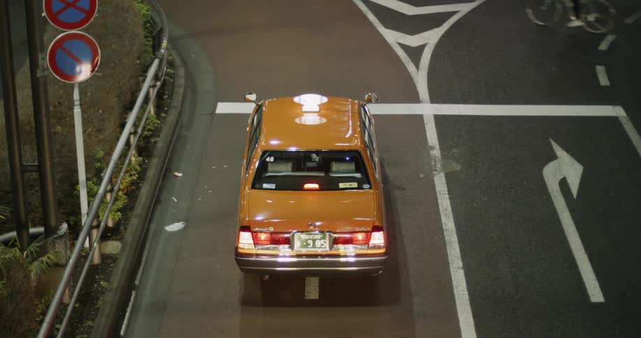 A yellow car sits at a stoplight