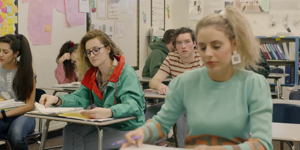 Many teenagers sit in a classroom