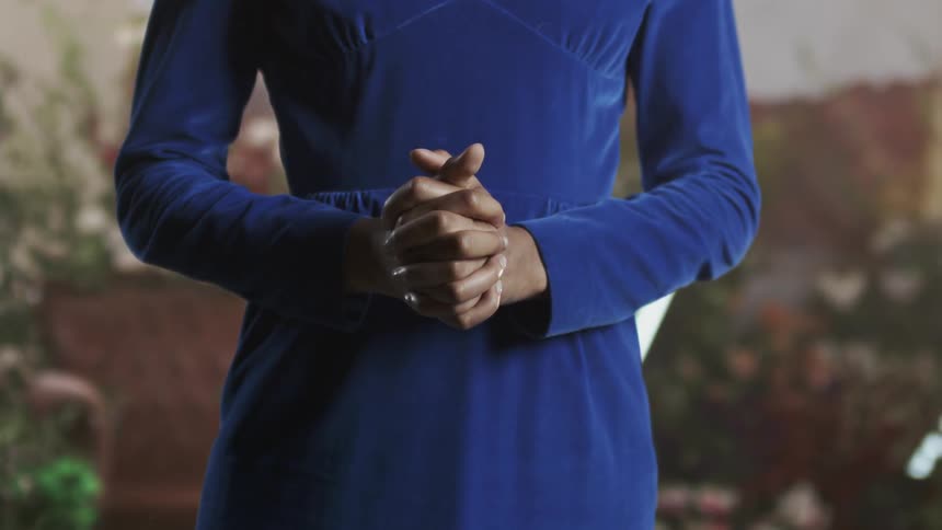 A woman presses her hands together