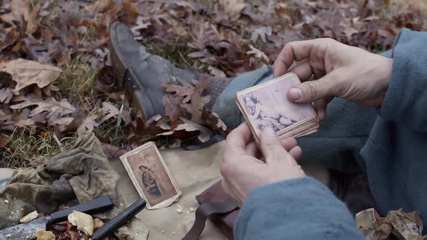 A man flips through some old photographs