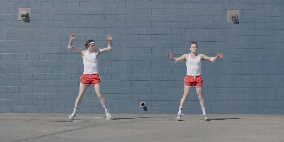 Two men do jumping jacks