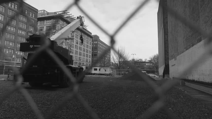 Large crane before some buildings on a cloudy day