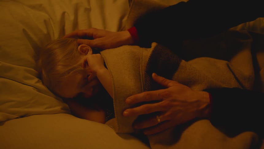 A young child is put to bed