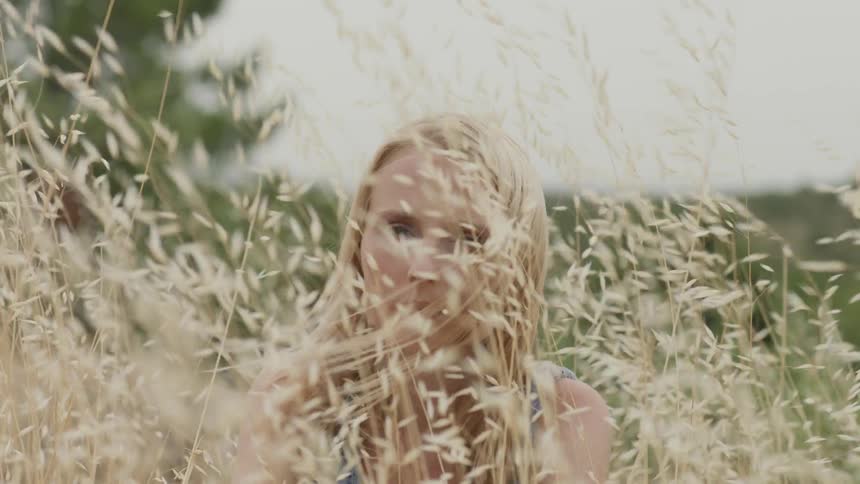A woman is sitting in the tall grass
