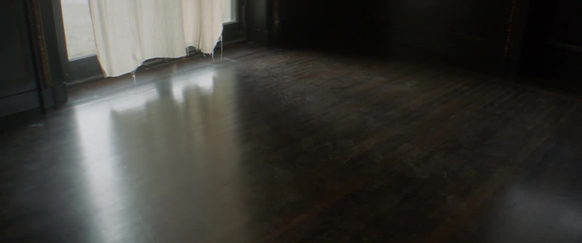 The sun is shining past the curtain near the door
