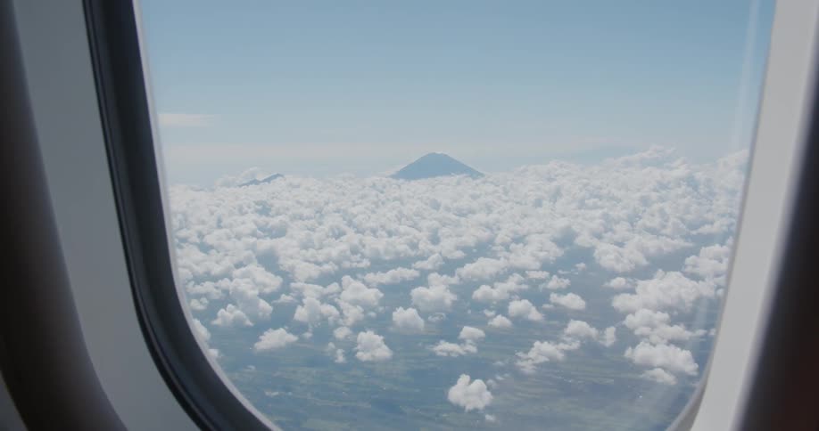 Out of the plane window the clouds can be seen below