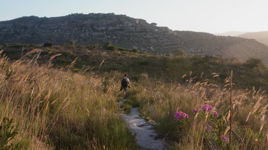 A man walks through the grass on the hill