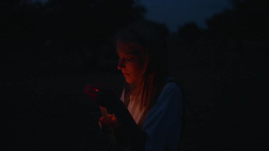 A woman is lighting a candle at night time