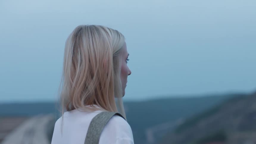 A woman stands on an overlook