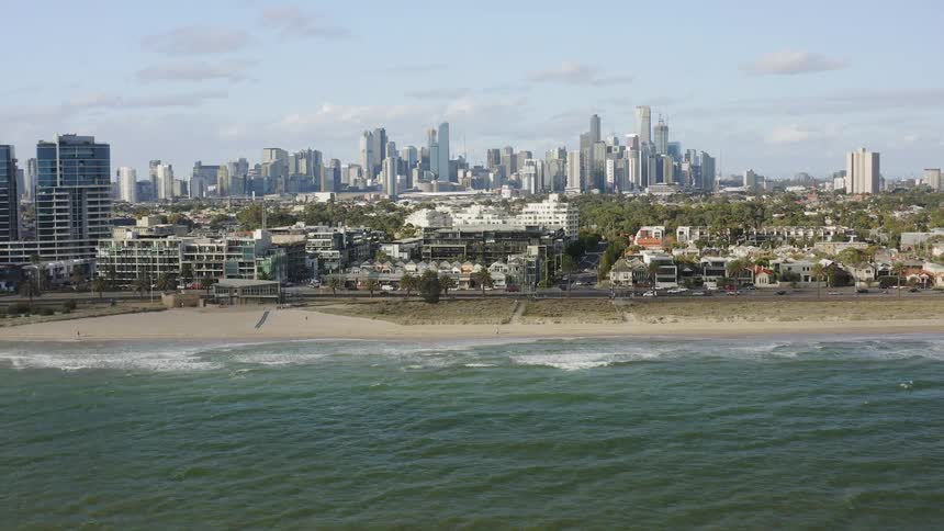 City on the edge of a large body of water with rolling waves