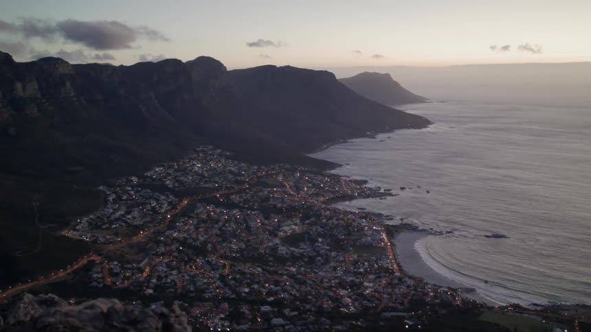 The waves are crashing against the shore near the town