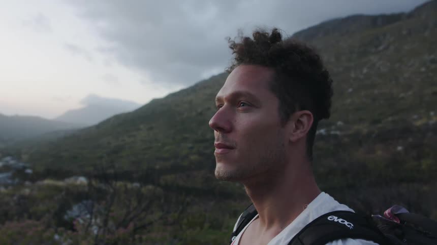 A man stands outside by the mountain