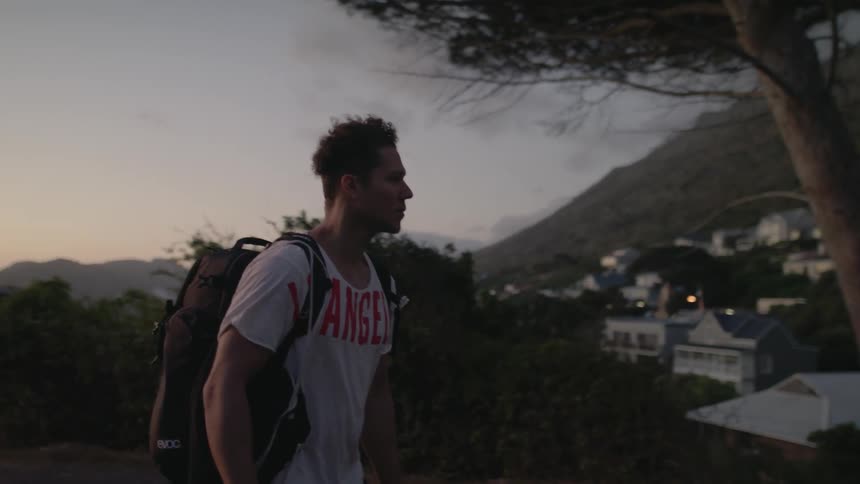 Man walks on a rural road at sunset