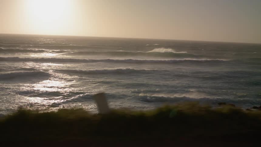 Ocean waves break and splash at sunset