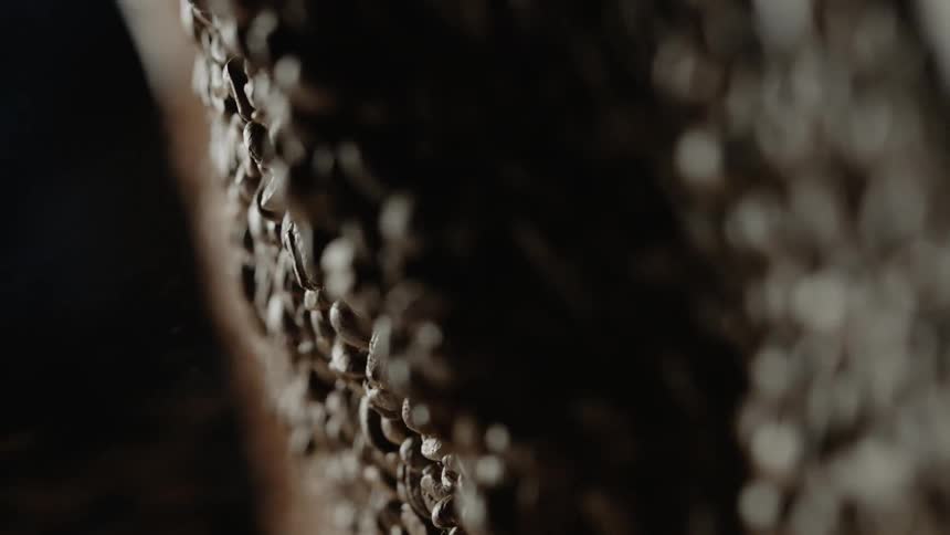 Coffee beans spill into a large pile of coffee beans