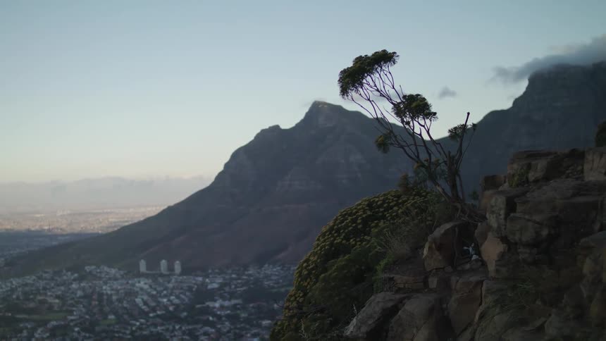City in the valley below mountains at sunset