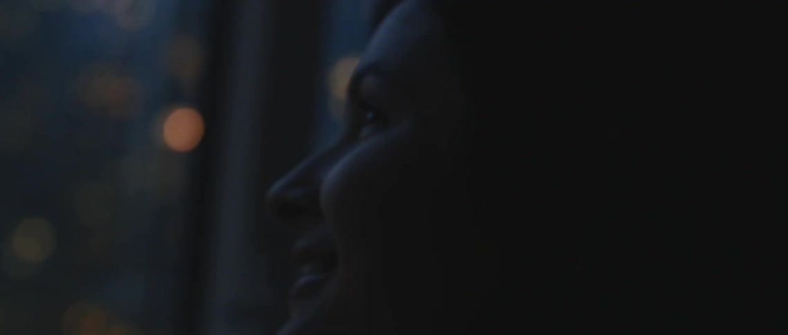 A woman looking out a window and smiling