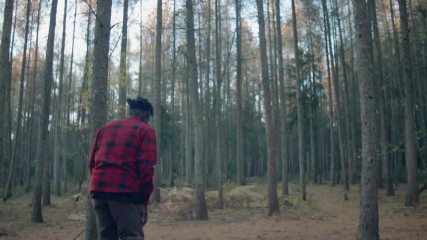 Man limps and stumbles in a forest