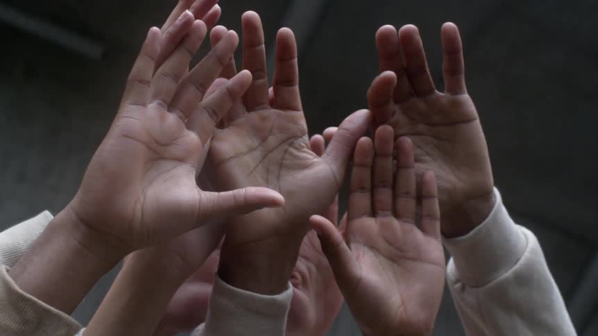 People's hands raised together