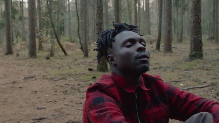 A man is sitting in the forest