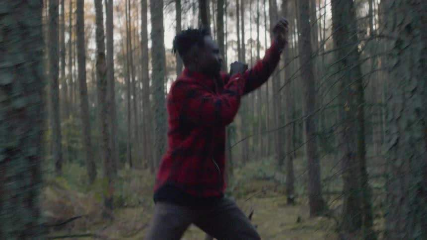 Man stumbles through the woods limping on one leg